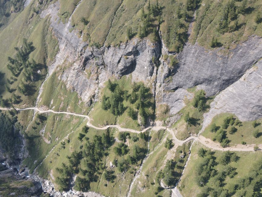 Aerial shot of a winding trail through Alpe Veglia's scenic mountain landscape in Piemonte, Italy.