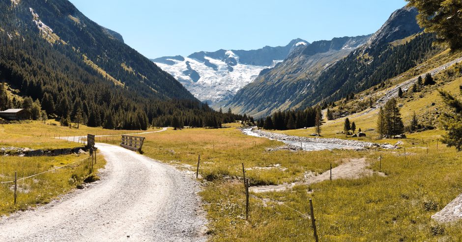Stunning landscape of Schönangerl Valley in Salzburg, Austria, showcasing a dirt path, lush greenery, and towering mountains.